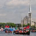 The Kitigan Zibi flotilla passes St Francis de Sales Church along the Pointe-Gatineau waterfront. 