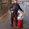 John Savage manoevering his canoe through the flood waters, 2019.